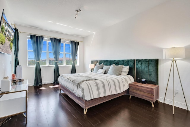 bedroom with baseboards and wood finished floors