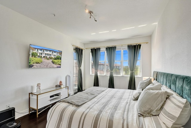 bedroom featuring dark wood-style floors and baseboards