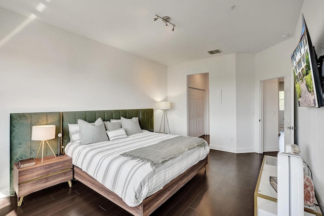 bedroom featuring wood finished floors, visible vents, and baseboards