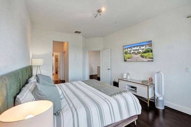 bedroom featuring wood finished floors, visible vents, and baseboards