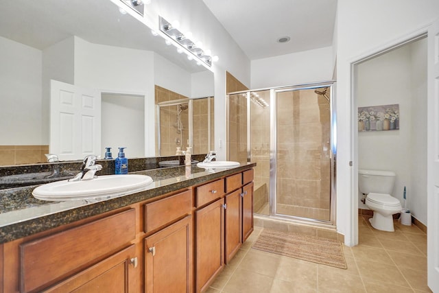 full bath with a stall shower, a sink, toilet, and tile patterned floors