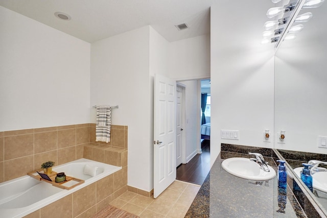 bathroom with visible vents, ensuite bath, tile patterned floors, a garden tub, and vanity