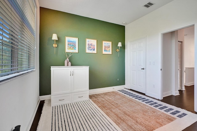 interior space with visible vents, baseboards, and wood finished floors