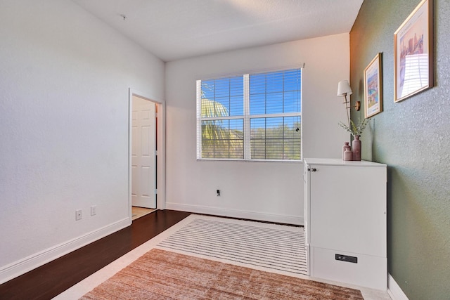 interior space featuring wood finished floors and baseboards