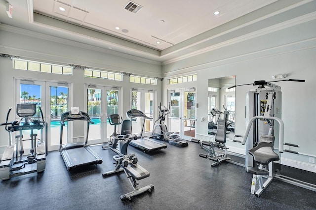 workout area with baseboards, visible vents, a tray ceiling, crown molding, and french doors