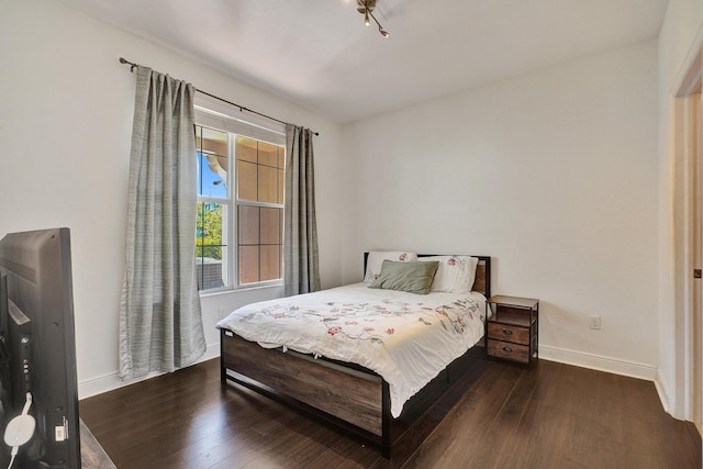 bedroom featuring baseboards and wood finished floors