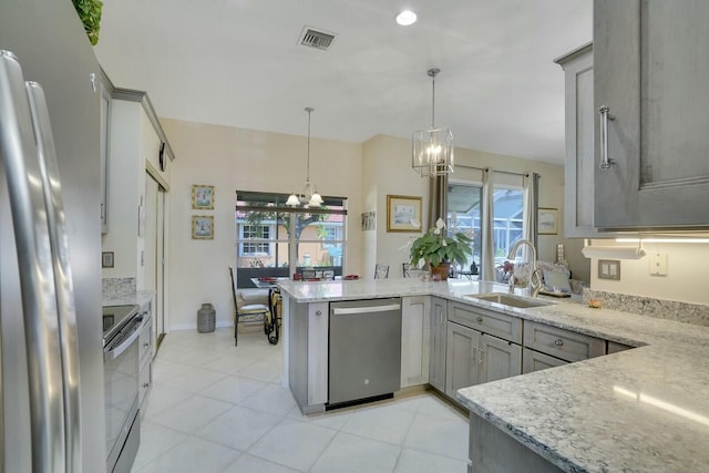 kitchen with stainless steel appliances, gray cabinetry, a sink, a chandelier, and a peninsula