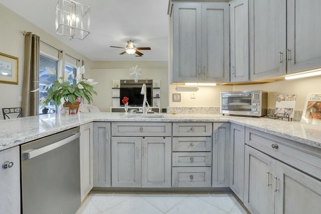 kitchen featuring light stone counters, a toaster, a sink, gray cabinets, and dishwasher