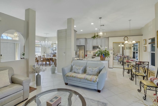 living room featuring recessed lighting, light tile patterned floors, baseboards, and an inviting chandelier