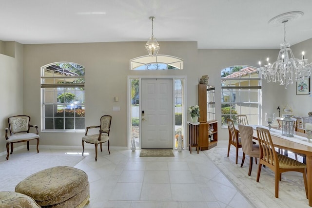 foyer with light tile patterned flooring, baseboards, and an inviting chandelier