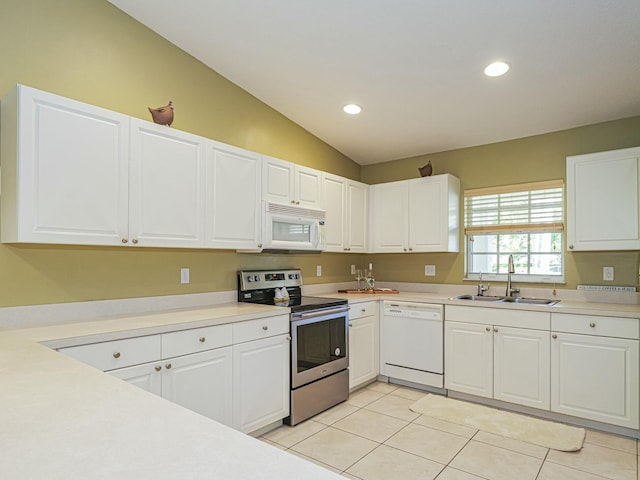 kitchen with a sink, white appliances, light tile patterned flooring, and white cabinetry