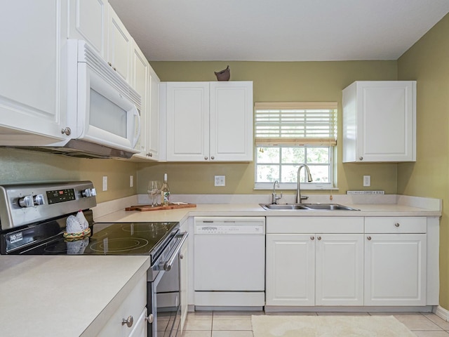 kitchen with white appliances, white cabinets, light countertops, and a sink