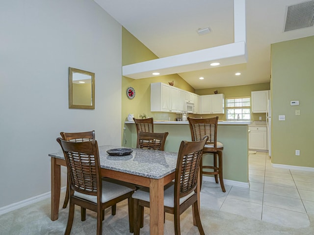 dining area featuring visible vents, baseboards, lofted ceiling, light tile patterned floors, and recessed lighting