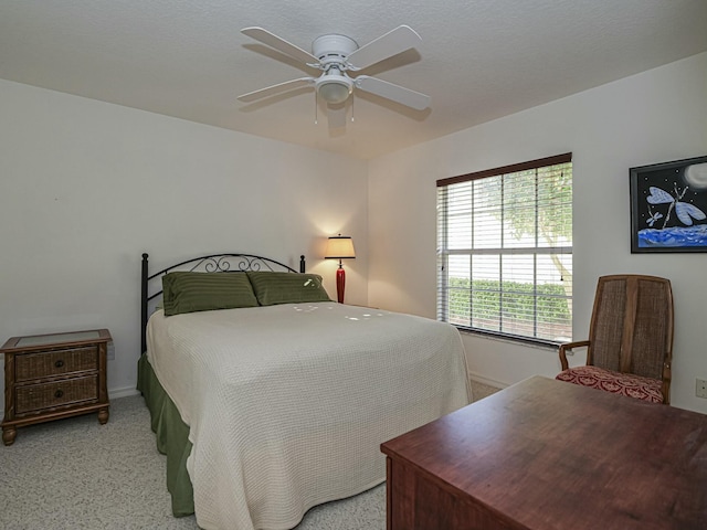 bedroom featuring light colored carpet, baseboards, and ceiling fan