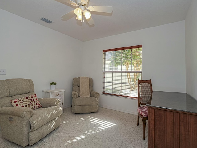 living area with baseboards, visible vents, and ceiling fan