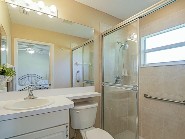 ensuite bathroom featuring ceiling fan, toilet, a stall shower, ensuite bathroom, and vanity