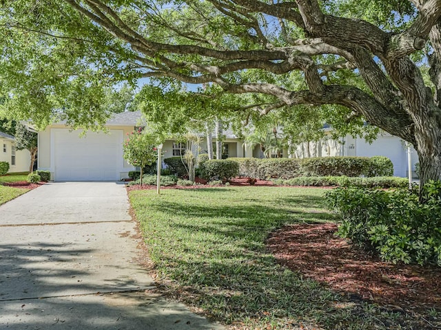 view of front of property featuring a garage, stucco siding, driveway, and a front lawn