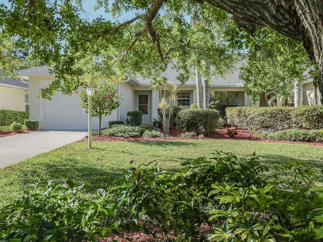 view of front facade with a front yard, driveway, an attached garage, a shingled roof, and stucco siding