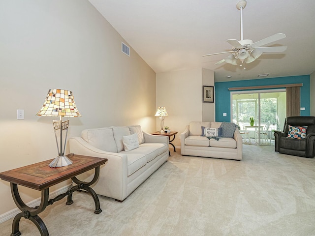 living area with baseboards, visible vents, lofted ceiling, ceiling fan, and light carpet