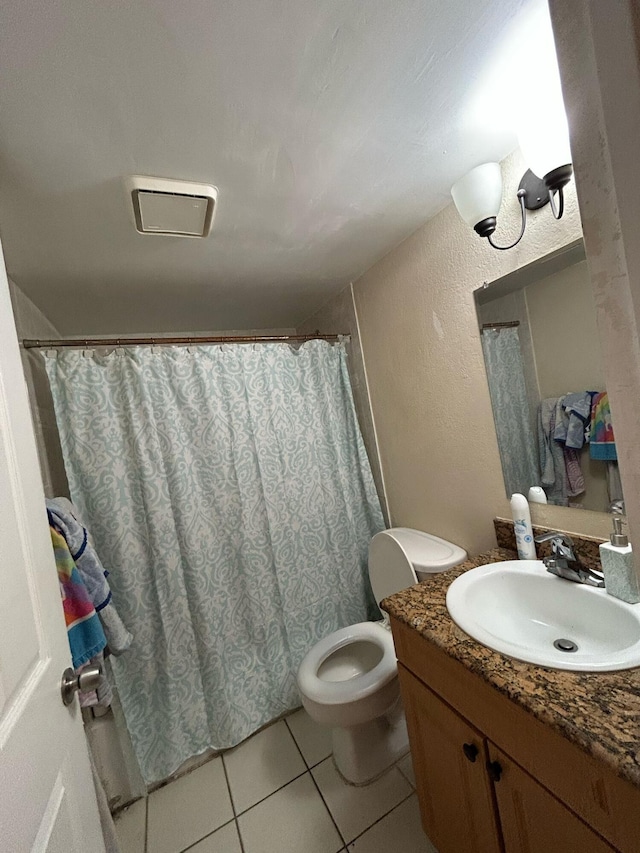 bathroom with a textured wall, toilet, a shower with curtain, tile patterned floors, and vanity