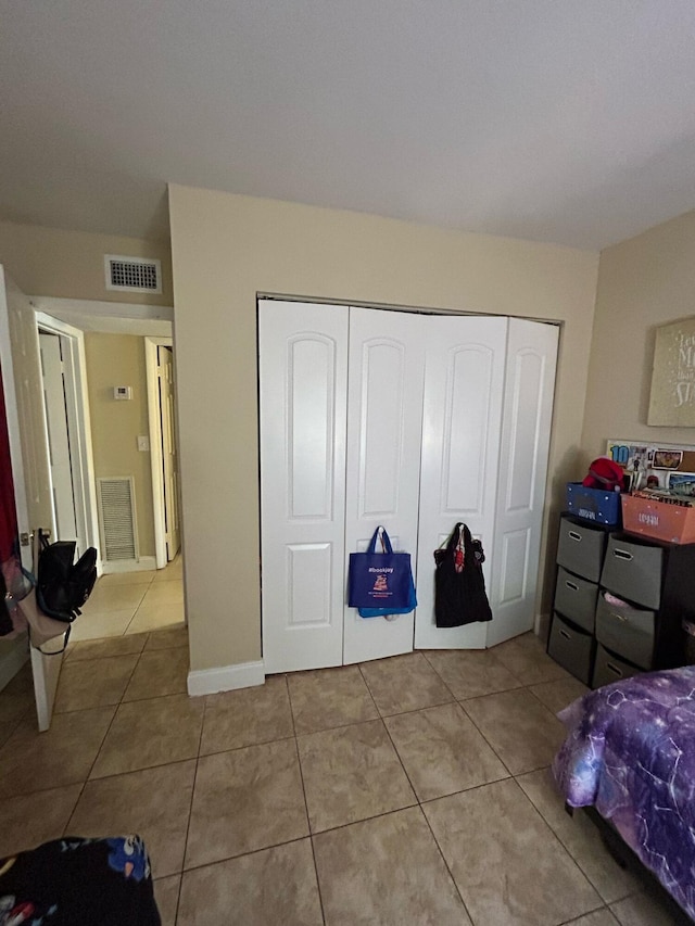 tiled bedroom featuring a closet and visible vents