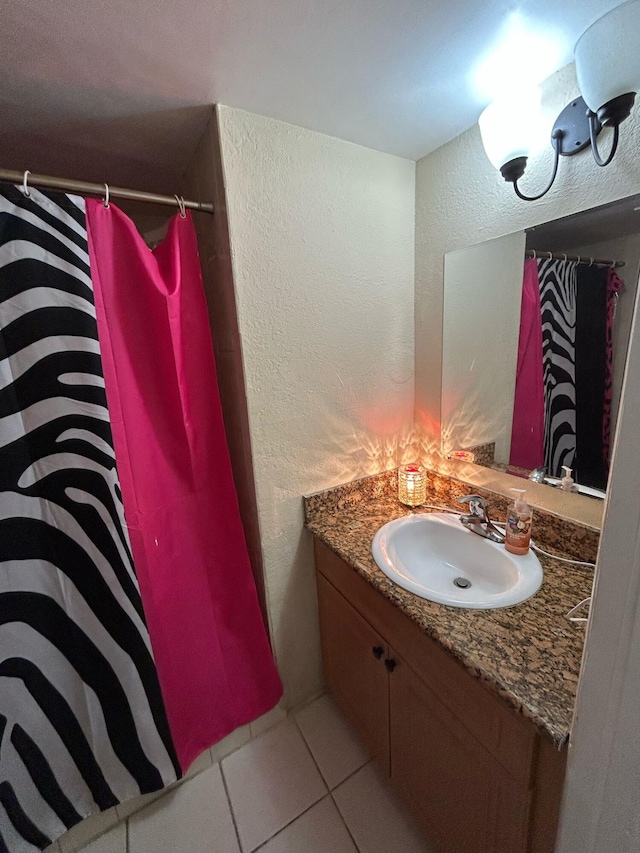 bathroom featuring a textured wall, vanity, a shower with shower curtain, and tile patterned floors