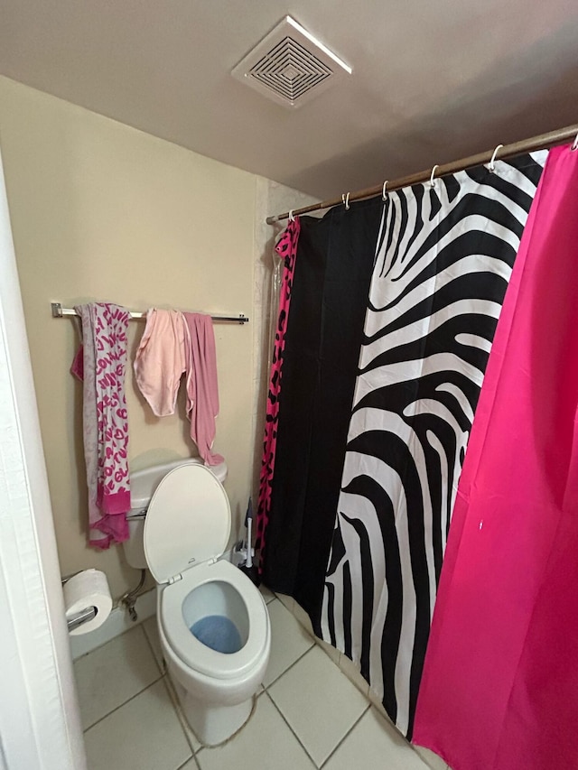 bathroom featuring toilet, a shower with shower curtain, tile patterned flooring, and visible vents