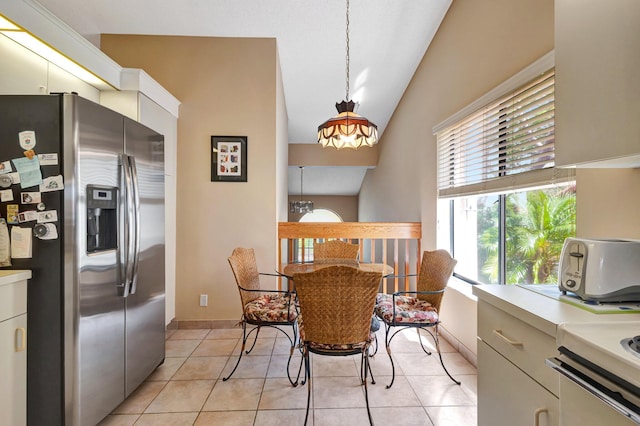 dining room featuring light tile patterned floors, vaulted ceiling, and a toaster