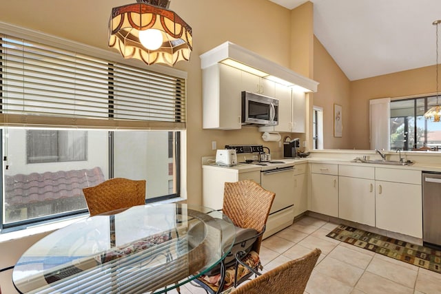 kitchen featuring pendant lighting, light tile patterned floors, light countertops, appliances with stainless steel finishes, and a sink