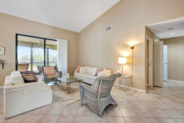 living room with light tile patterned floors, baseboards, visible vents, and high vaulted ceiling