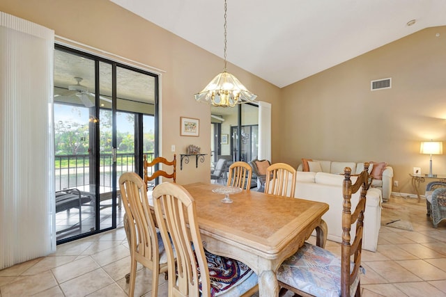 dining area with light tile patterned floors, high vaulted ceiling, ceiling fan with notable chandelier, visible vents, and baseboards