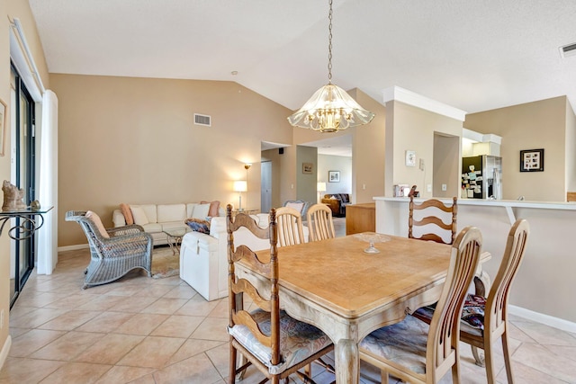 dining room featuring a chandelier, visible vents, vaulted ceiling, and light tile patterned floors