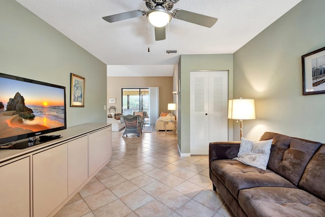 living area with light tile patterned flooring, ceiling fan, and a textured ceiling