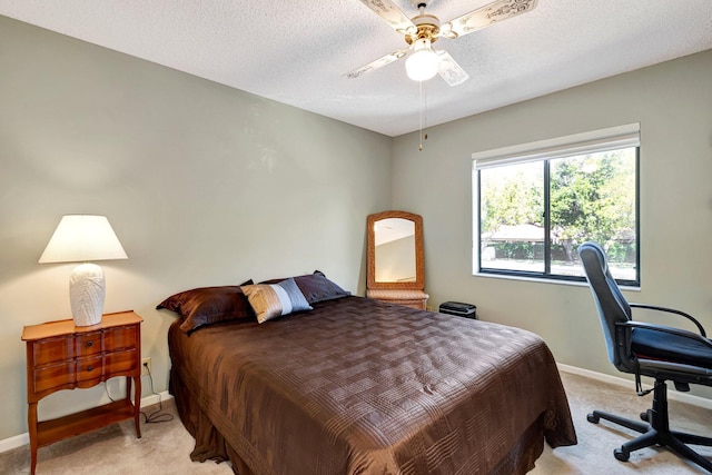 bedroom with ceiling fan, baseboards, a textured ceiling, and light colored carpet