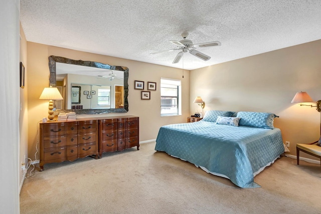 carpeted bedroom featuring ceiling fan, a textured ceiling, and baseboards