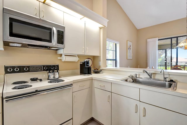 kitchen with electric range, lofted ceiling, stainless steel microwave, light countertops, and a sink