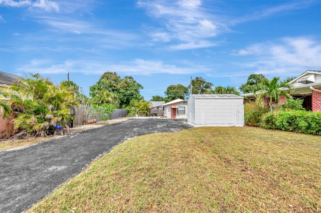 view of yard featuring an outbuilding and fence