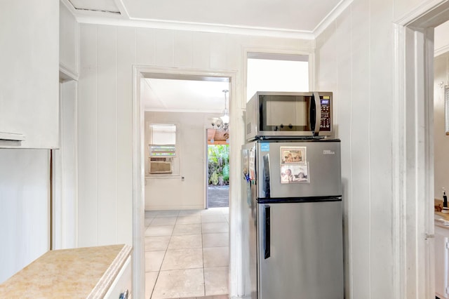 kitchen featuring light tile patterned floors, cooling unit, appliances with stainless steel finishes, and crown molding