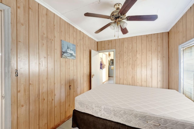 bedroom featuring a ceiling fan, crown molding, and wood walls