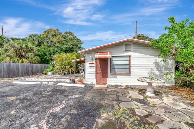 view of front of house with uncovered parking and fence