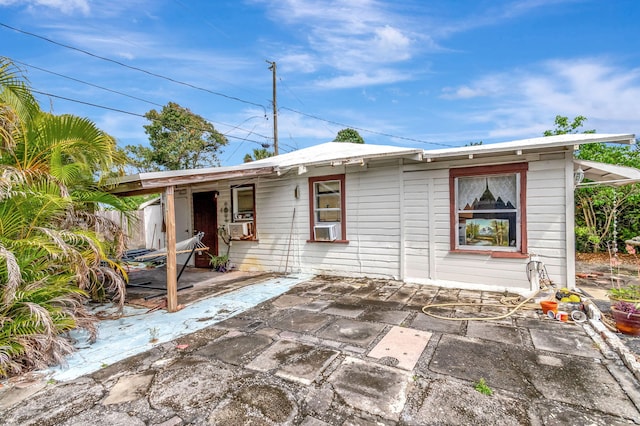 rear view of house with a patio area and cooling unit