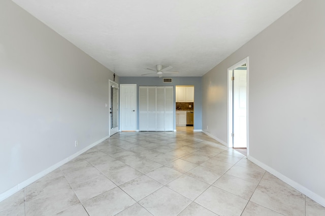 empty room featuring visible vents, baseboards, and a ceiling fan