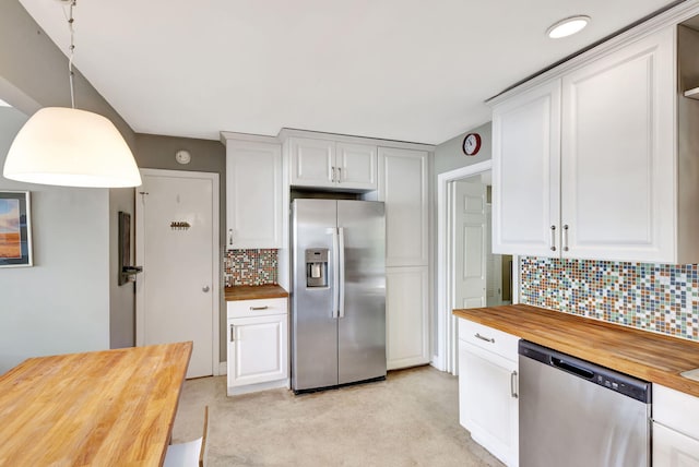 kitchen featuring stainless steel appliances, wood counters, white cabinets, backsplash, and pendant lighting