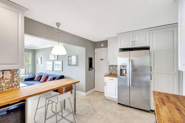 kitchen with butcher block counters, white cabinetry, backsplash, and stainless steel fridge with ice dispenser