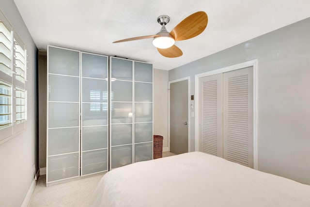 carpeted bedroom with a ceiling fan, a closet, and baseboards