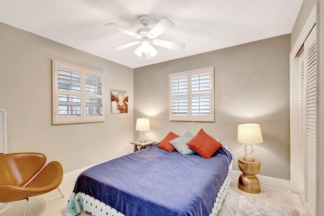 carpeted bedroom featuring a closet, a ceiling fan, and baseboards