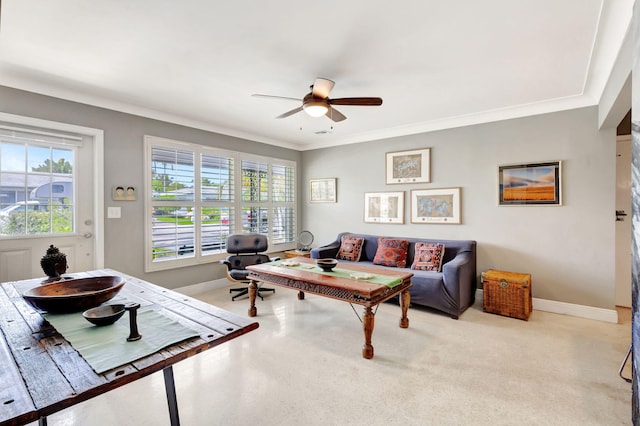 living room with carpet floors, ornamental molding, a ceiling fan, and baseboards