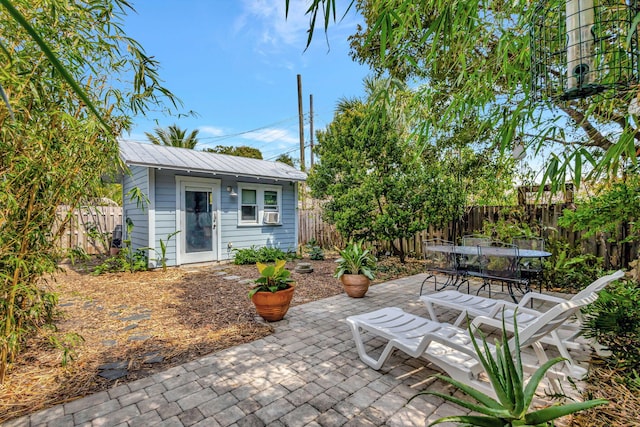 view of patio featuring outdoor dining space, a fenced backyard, and an outdoor structure