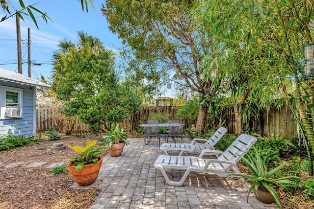 view of patio / terrace featuring cooling unit, outdoor dining area, and a fenced backyard