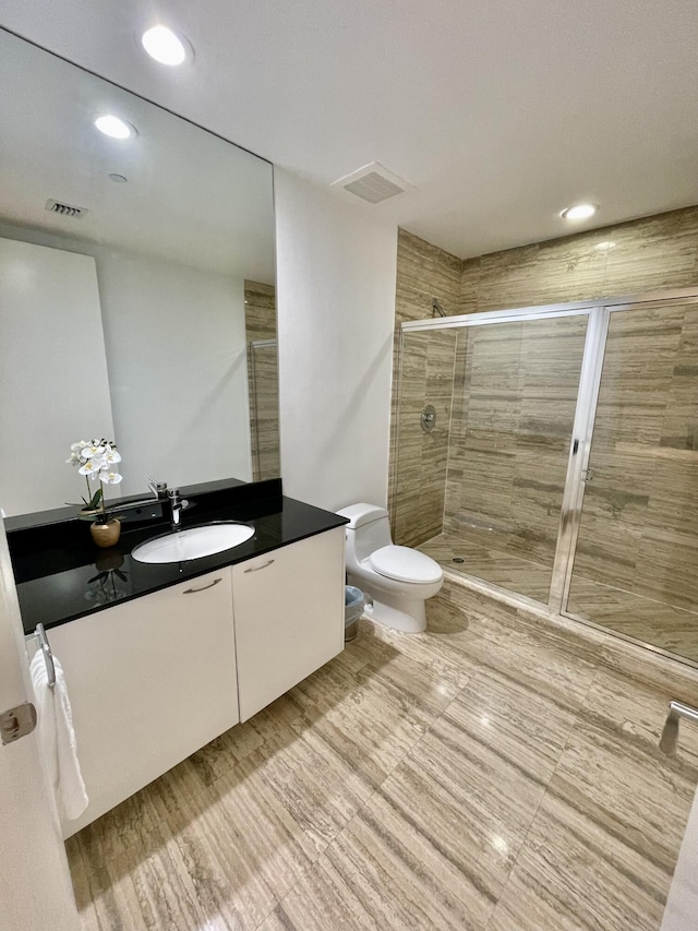 full bath featuring toilet, a stall shower, vanity, and visible vents